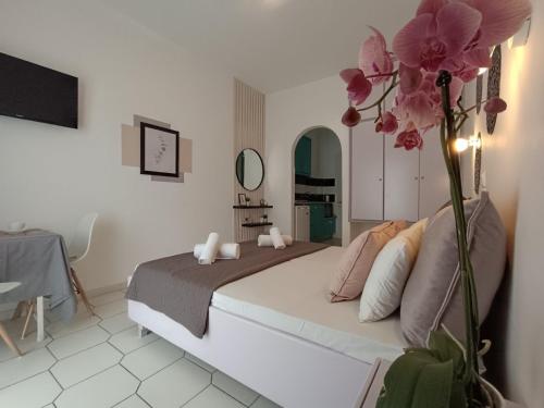um quarto com uma cama com um vaso de flores em Philippos Apartments em Acharavi