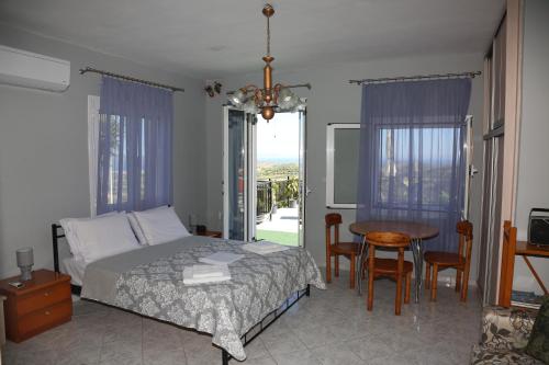 a bedroom with a bed and a table and chairs at Ionian Overlook in Lixouri