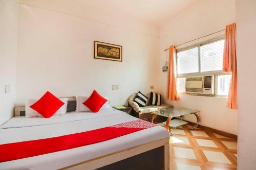a bedroom with a bed with red pillows and a window at Kesher Paying Guest House in Varanasi