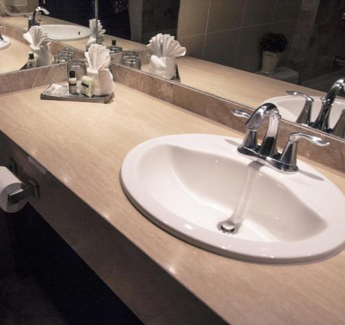 a white sink sitting under a mirror in a bathroom at Fantasyland Hotel in Edmonton