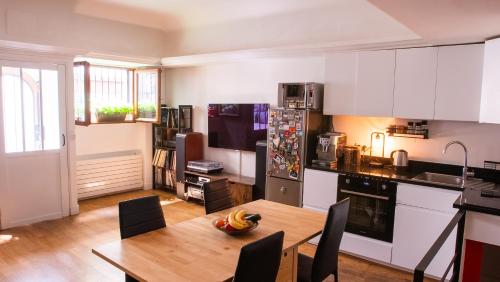 une cuisine avec une table en bois et une salle à manger dans l'établissement Atelier artiste à Montmartre, à Paris