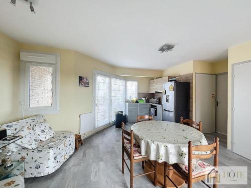 a room with a table and a couch and a kitchen at Le Petit Golf - Balcon, Plage à 50m in Bray-Dunes