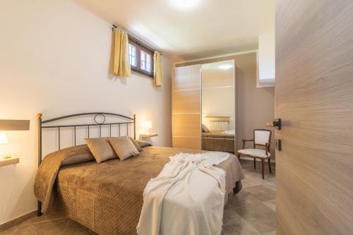 a bedroom with a bed and a chair and a door at La casa di Lola in Monterosi