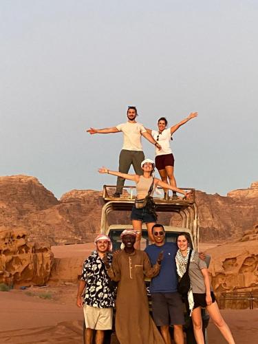 a group of people standing on the top of a vehicle at Desert Bedouin adventure in Wadi Rum