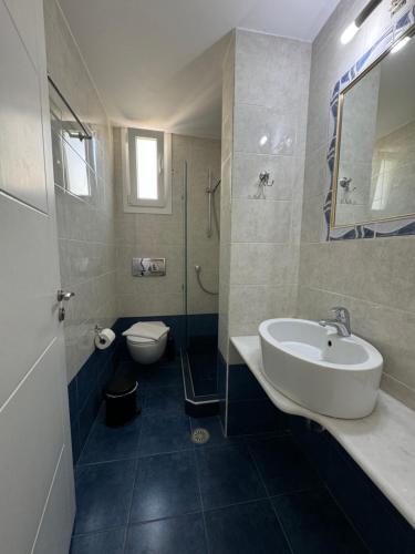 a bathroom with a sink and a toilet at Naxos Lane Center Studios in Naxos Chora