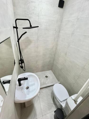 a white bathroom with a sink and a toilet at Greenwood in Borjomi