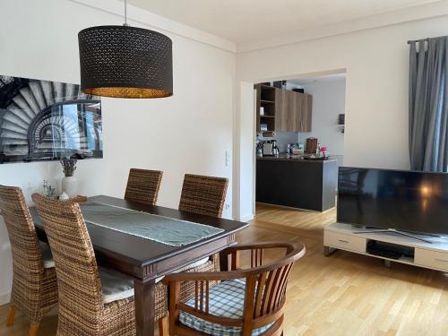 a dining room with a table and chairs and a television at Ferienwohnung Schneider&Graf in Utting
