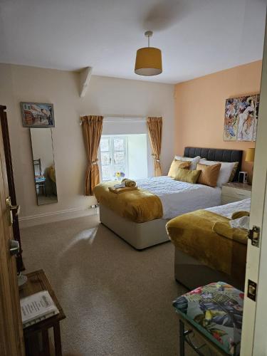 a bedroom with two beds and a mirror at Sheviock Barton Bed & Breakfast in Sheviock