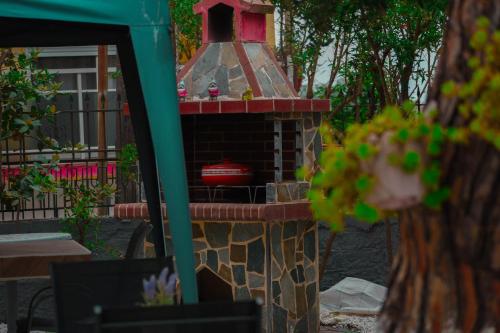 a brick fireplace with a bird house in a yard at Teo Apartments Luxury ll in Kavala