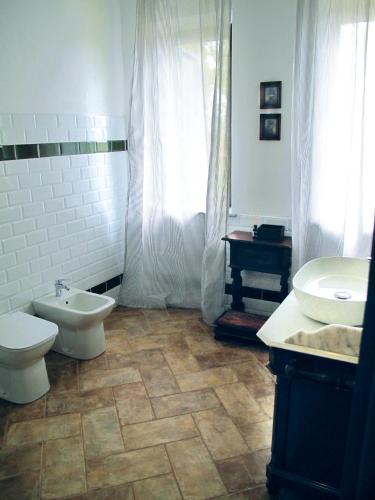 a bathroom with a toilet and a bidet and a sink at Cascina Pelizza in Casale Monferrato