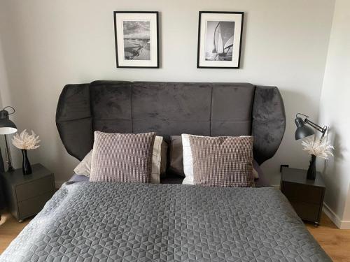 ein Bett mit einem großen Kopfteil in einem Schlafzimmer in der Unterkunft Red bridge Resort - Apartament & SPA in Dziwnów