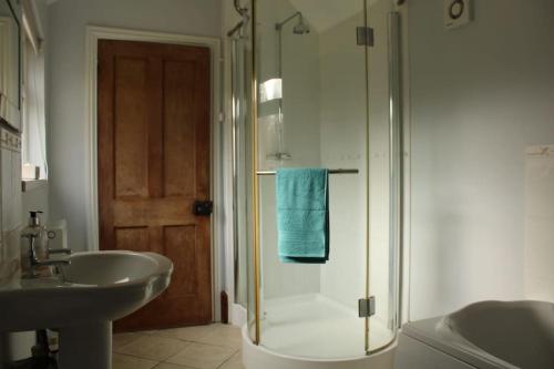 a bathroom with a glass shower and a sink at Helene - Dog Friendly Family Home on Norfolk Coast in Potter Heigham