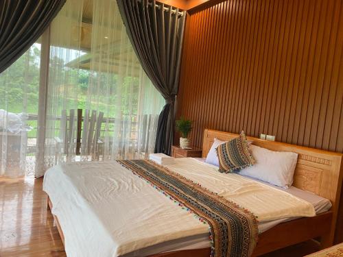 a bedroom with a large bed with a large window at VuLinh Family -Homestay in Yên Bình