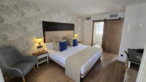 a bedroom with a large bed and a chair at VISTALEGRE Hotel-Spa in Portomarin