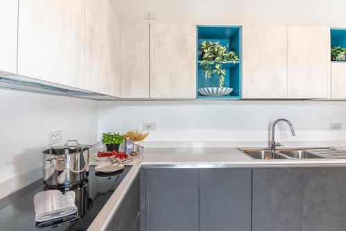 a kitchen with white cabinets and a sink at VILLA SANT'ANNA by Curtiaffitti in Pianello Del Lario