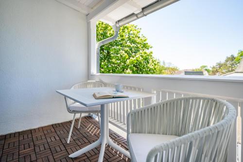 a table and chairs on a balcony with a window at Strandvilla Glückauf in Binz