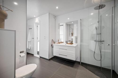 ein weißes Badezimmer mit Toilette und Dusche in der Unterkunft Familieresort i Bavallen in Skulestadmo