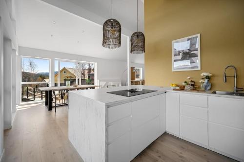 eine Küche mit weißen Schränken und einem großen Fenster in der Unterkunft Familieresort i Bavallen in Skulestadmo