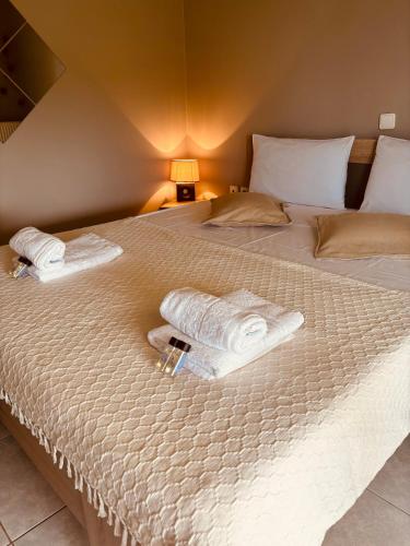 a bed with two towels on top of it at Villa Oneiropagida in Preveza