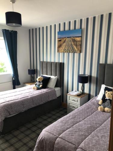 2 Betten in einem Hotelzimmer mit 2 Teddybären in der Unterkunft Seacrest in Galway