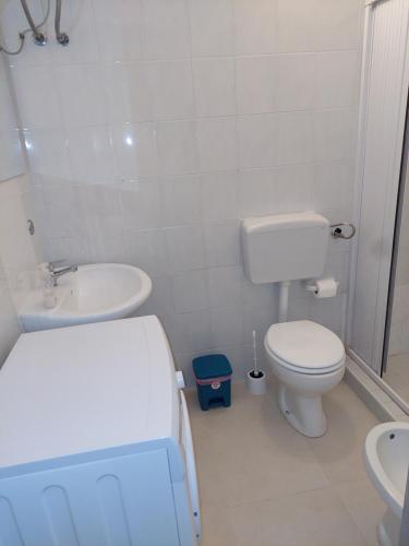 ein weißes Bad mit einem WC und einem Waschbecken in der Unterkunft Casa Rizza in Portopalo