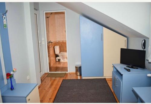a room with a blue desk and a bathroom at Family Hotel Miglena in Govedartsi