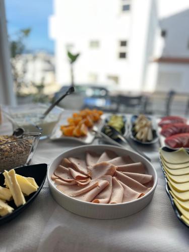 a table topped with different types of meats and cheese at ALNES HOTEL in Sarandë