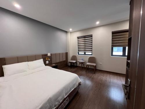a bedroom with a bed and a table and two chairs at Hà Vy Homstay in Móng Cái
