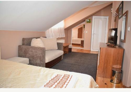 a hotel room with a bed and a couch at Family Hotel Miglena in Govedartsi