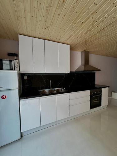 a kitchen with white cabinets and a black counter top at Apartamento Loft con 2 dormitorios, Jacuzzi y Garage in Cambrils