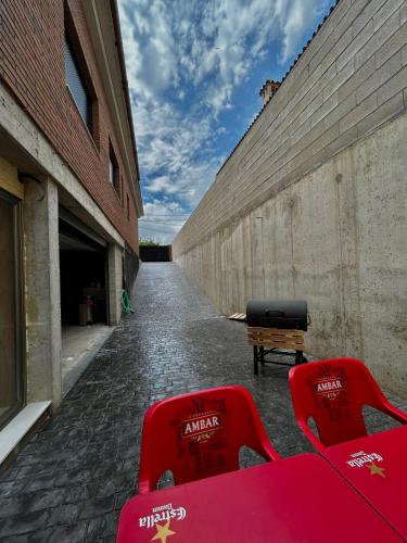 two red chairs sitting next to a brick wall at Apartamento Loft con 2 dormitorios, Jacuzzi y Garage in Cambrils