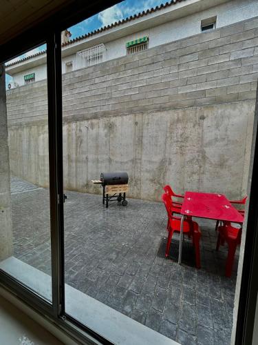 a window with a red table and chairs and a bench at Apartamento Loft con 2 dormitorios, Jacuzzi y Garage in Cambrils