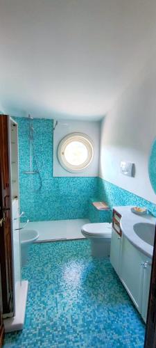 a blue bathroom with a toilet and a sink at Le Quattro Stagioni in Massa