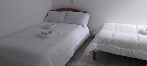 a white bed with two bowls on top of it at hotel S & C in Sogamoso