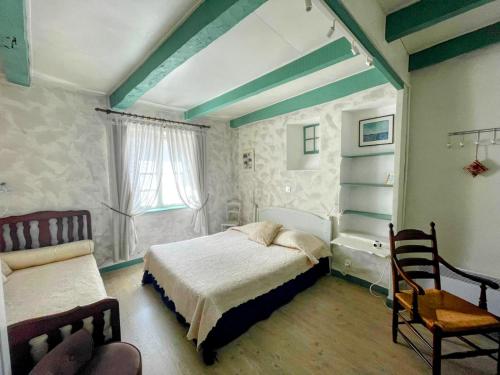 a bedroom with a bed and a chair at Maison du Manoir in Vallon-Pont-dʼArc