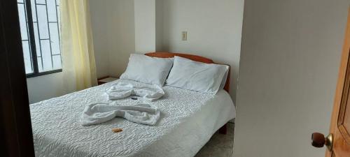 a bedroom with a bed with a towel on it at hotel S & C in Sogamoso