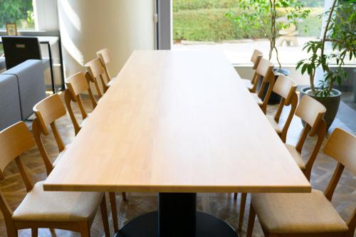 a wooden table in a room with chairs at Miyajima Coral Hotel in Miyajima