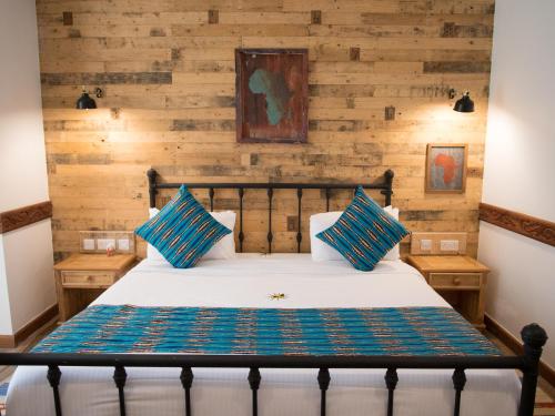 a bedroom with a bed with wooden walls at Small World Country Club in Athi River