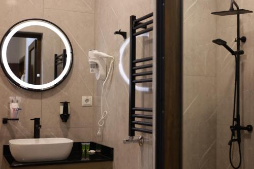 a bathroom with a sink and a mirror at Fiorella Gyumri in Gyumri