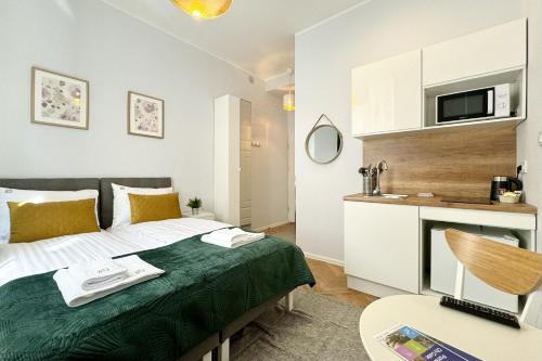 um quarto de hotel com uma cama e uma cozinha em KRAMARSKA Residence - Old Market Square by Friendly Apartments em Poznań