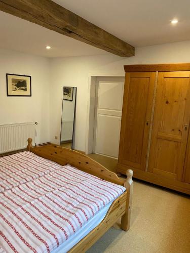 a bedroom with a bed and a wooden cabinet at Schloßbergwohnung Löwenhaus in Homberg