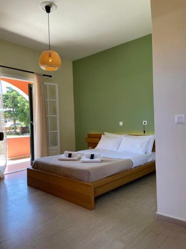 a bedroom with a large bed and a green wall at Alexandra's Apartments in Sidari