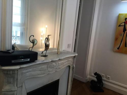 un salon avec une cheminée, une télévision et une bougie dans l'établissement 5 minutes Village Olympique Tour Eiffel, à Paris