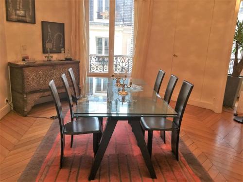 une salle à manger avec une table et des chaises en verre dans l'établissement 5 minutes Village Olympique Tour Eiffel, à Paris