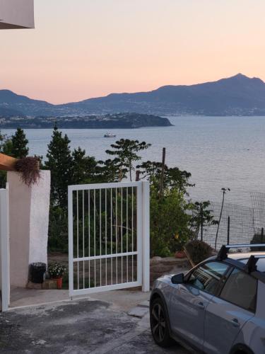 une porte blanche avec une voiture garée devant l'eau dans l'établissement Al Panorama di Ercole, à Monte di Procida