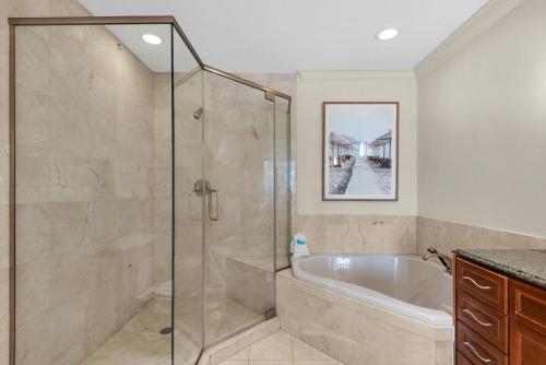 y baño con bañera y cabina de ducha acristalada. en Emerald Grande W223 en Destin