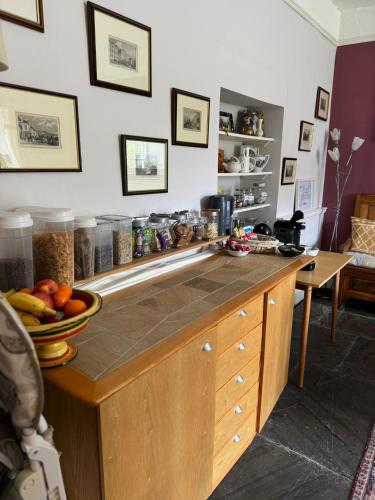 a kitchen with a counter with a bowl of fruit on it at Sheviock Barton Bed & Breakfast in Sheviock