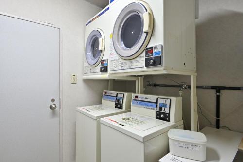 a hospital room with a washing machine and a toilet at Miyajima Coral Hotel in Miyajima