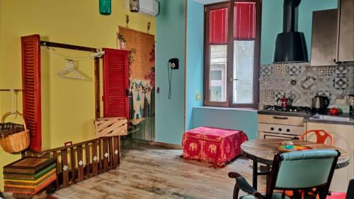 eine Küche mit gelben und blauen Wänden, einem Tisch und einem Herd in der Unterkunft Famme sta cuiete apartment in Neapel