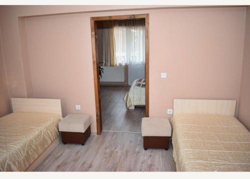 a room with two beds and a mirror at Family Hotel Miglena in Govedartsi